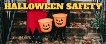 Halloween Safety. Two children in costume holding trick or treat buckets.